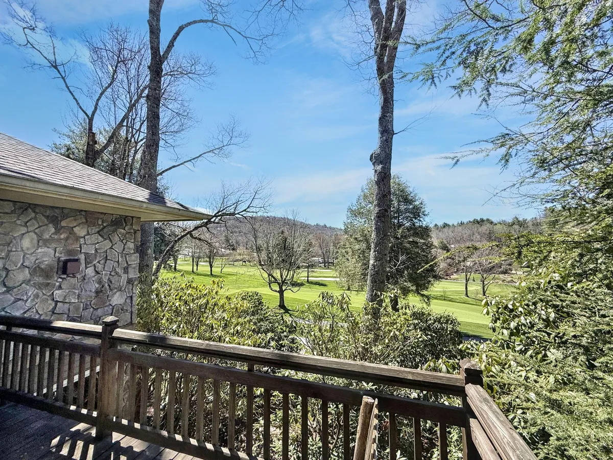 A scenic view of the Highlands Falls Country Club golf course, framed by trees and open sky, with tranquil, well-manicured greens. The wide perspective allows viewers to imagine the backdrop described in the section as the setting for outdoor meals or evening relaxation.
