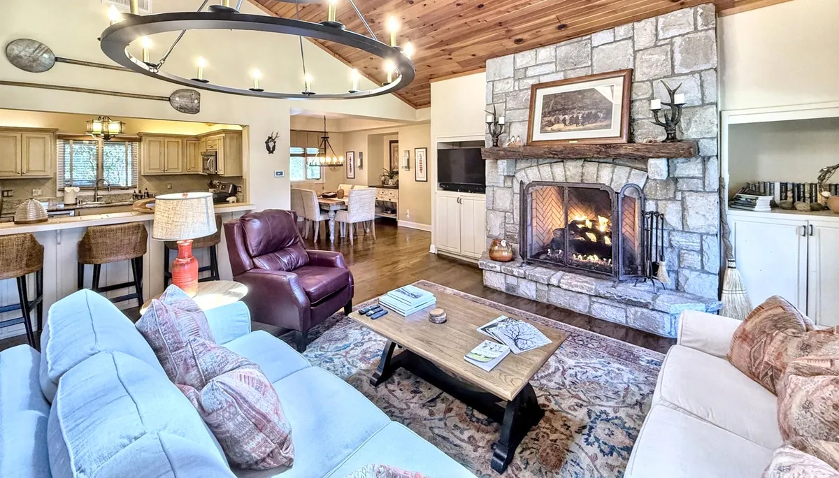 A warm living room with a welcoming fireplace, ample seating, and a coffee table, ideal for casual entertaining and socializing after a day of exploring.
